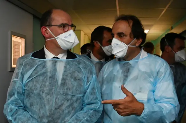 French Prime Minister Jean Castex (L) speaks with a doctor