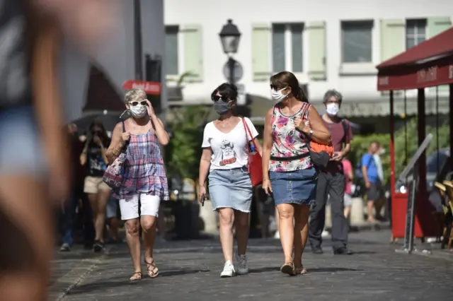 People wear a protective face mask in Montmartre district, in Paris, France