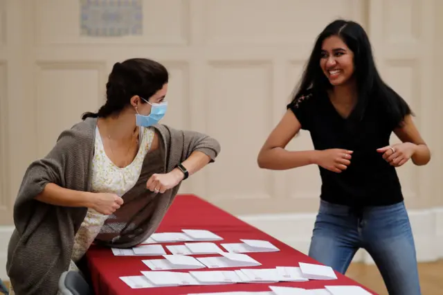 A student greets a teacher at Newham Collegiate Sixth Form after receiving her A-Level results in east London