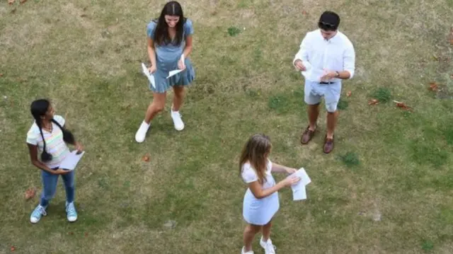 Students staying at a social distance receiving their results