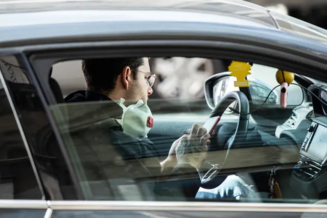 A man wearing a face mask in his car in Paris, France