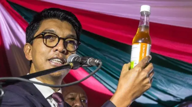 President Andry Rajoelina holds a bottle of Covid-Organics