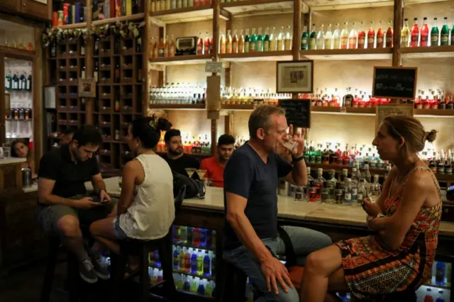 People sit at a bar in Athens