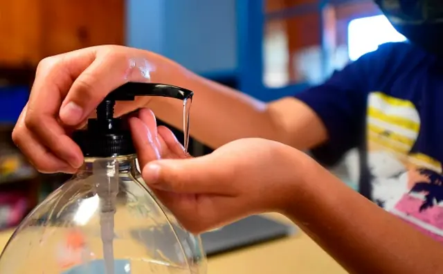 A child using hand sanitiser