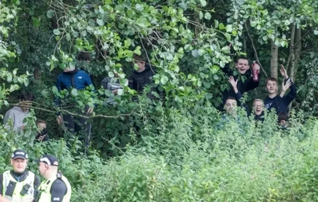 Fans in the woods outside the stadium