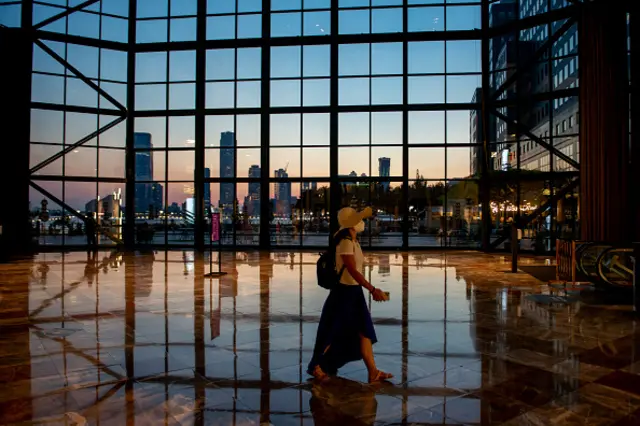 A woman wearing a mask is seen walking inside Brookfield Place shopping center during susnet as the city continues Phase 4 of re-opening following restrictions imposed to slow the spread of coronavirus on August 10, 2020 in New York City