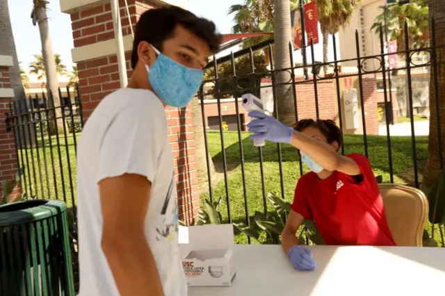 A University of Southern California student has his temperature checked on the first day of classes