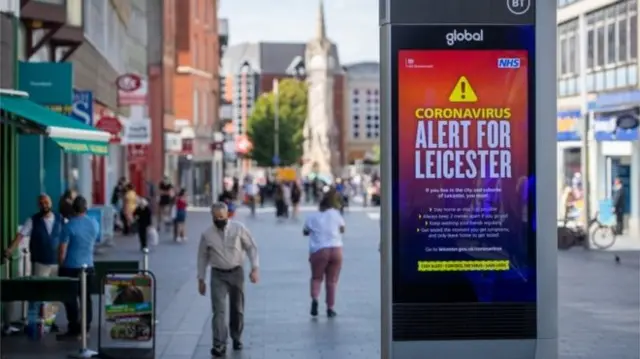 A street in Leicester, with a government advert warning of coronavirus in the city