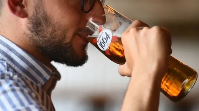 A person drinking a pint of beer