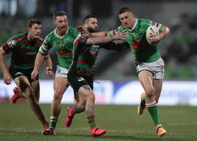 Canberra five-eighth Jack Wighton holds off Souths half-back Adam Reynolds