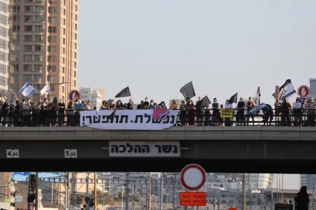 Israelis protest against Israeli Prime Minister Benjamin Netanyahu on a bridge in Ayalon Highway