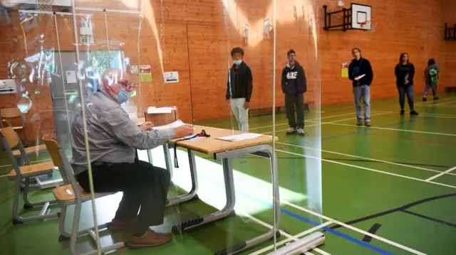 Secondary school students wait in line for their GCSE results at Kingsdale Foundation school in south London,