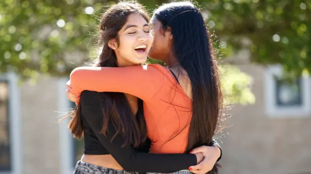 wins Esha (left) and Risha Gupta celebrate their GCSE results at The Grammar School at Leeds.