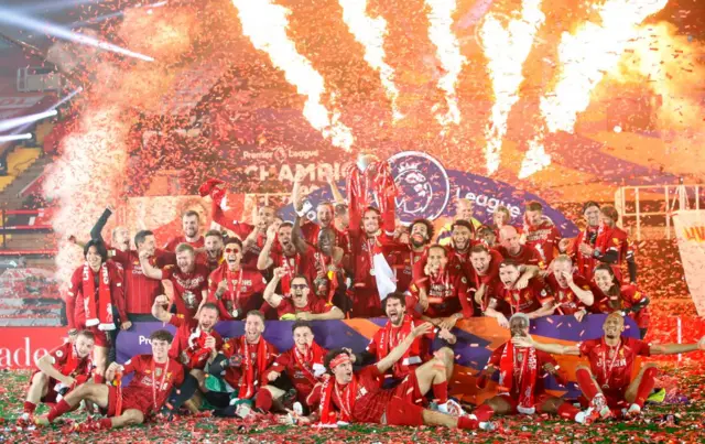 Liverpool squad celebrating with the Premier League trophy