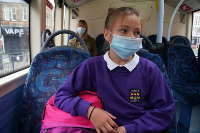 Child in mask on bus