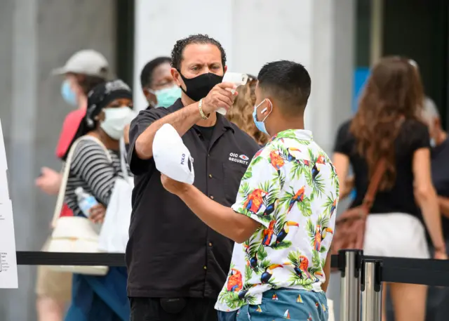 Shopper has his temperature checked in New York on 24 August 2020