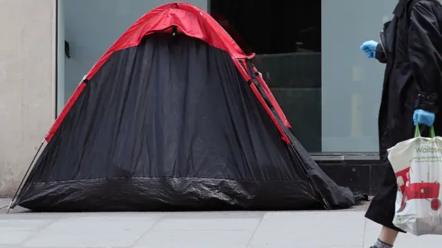 A tent for a homeless person on a street