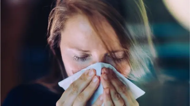 A woman sneezing