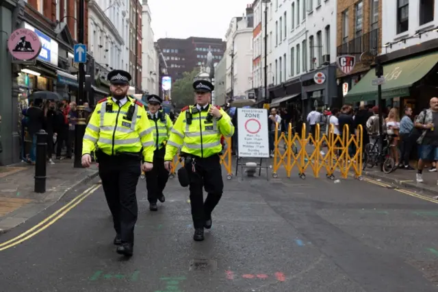 Police officers walk along the street of Soho, London as lockdown measures are eased on 4 July 2020