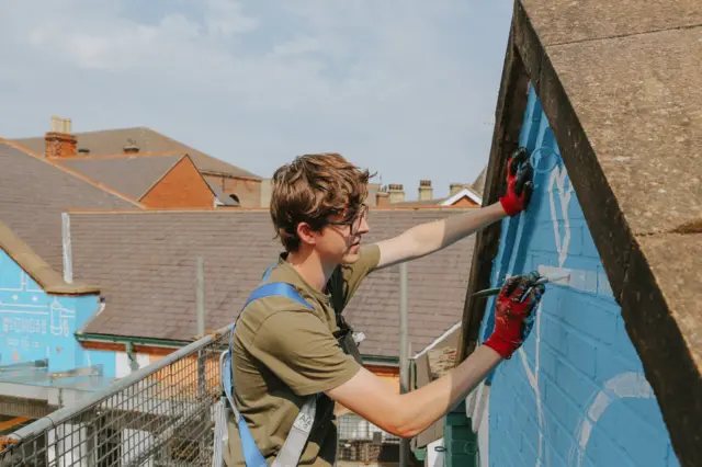 Will Rea painting the mural in Sheffield