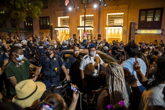 Protesters escort a man from Black Lives Matter plaza to near by police officer on August 27, 2020 in Washington, DC.