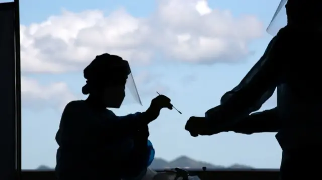 Health workers conducting swab tests