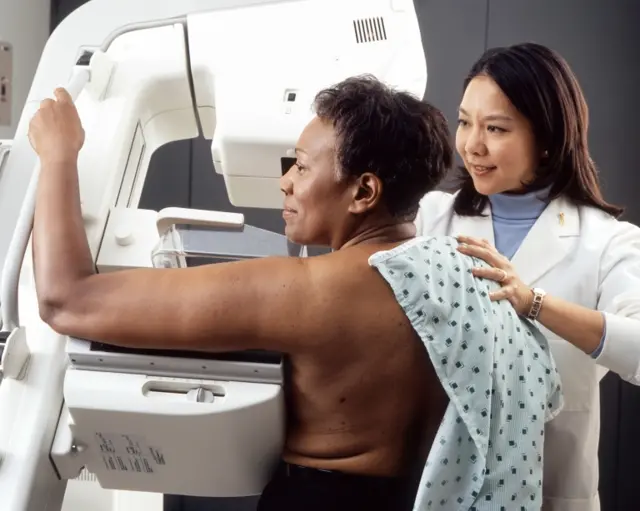 A woman is screened for breast cancer