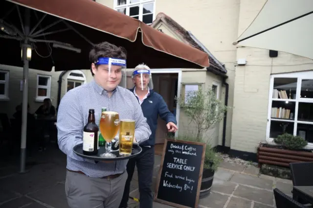 Bar staff serving drinkings with visor