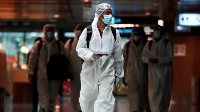 People wearing PPE at Singapore Airport