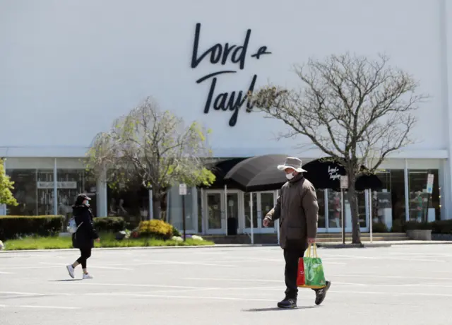 Pedestrians walk past a shuttered Lord and Taylor department store following their filing for bankruptcy amid the COVID-19 pandemic on May 12, 2020 in Garden City, New York.