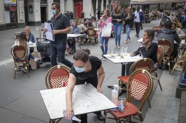 Tables being cleaned at Di Maggio"s outdoor restaurant area in Glasgow city centre.