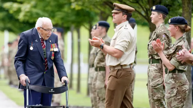 Captain Sir Tom Moore walks down a guard of honour during a visit to the Army Foundation College in Harrogate