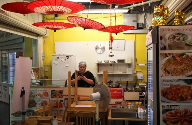 A worker at a Chinese restaurant at an indoor market