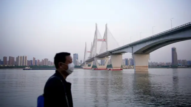 A man wearing a face mask is seen under a bridge of Yangtze river in Wuhan  in Wuhan