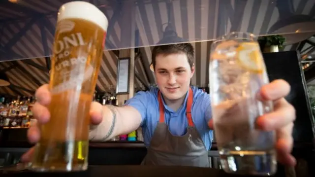 A barman serves two drinks