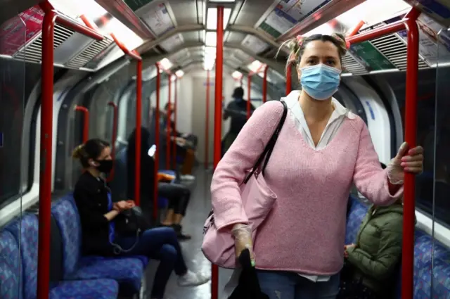 A woman wears a face covering on the London Underground