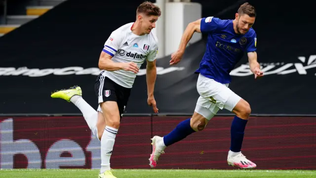 Fulham skippper Tom Cairney and Brentford's Henrik Daalsgard chase a ball