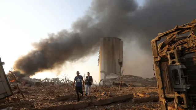 Men walk at the site of the explosion