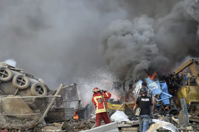 Firefighters try to extinguish flames after the explosion