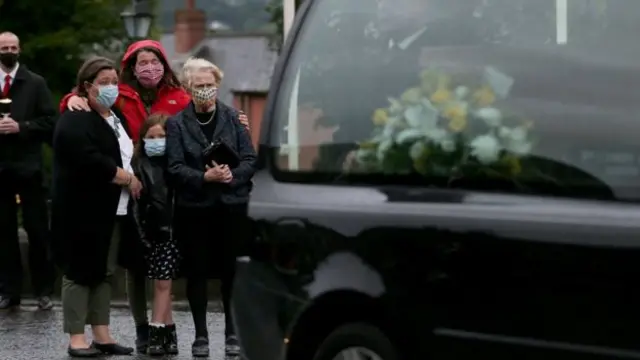 Mr Hume's wife and family watch as his coffin was taken to St Eugene's Cathedral in Derry on Tuesday evening