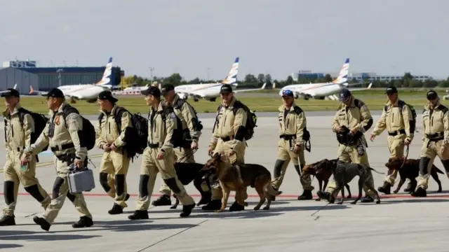 Members of a search and rescue team from the Czech Republic board a plane