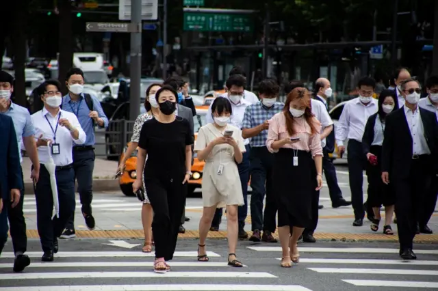 People wearing masks cross a street in Seoul, South Korea, 03 September 2020