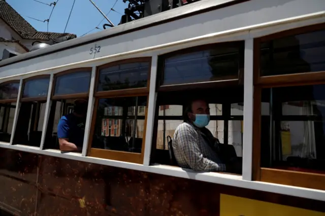 People wear masks on a tram in Lisbon