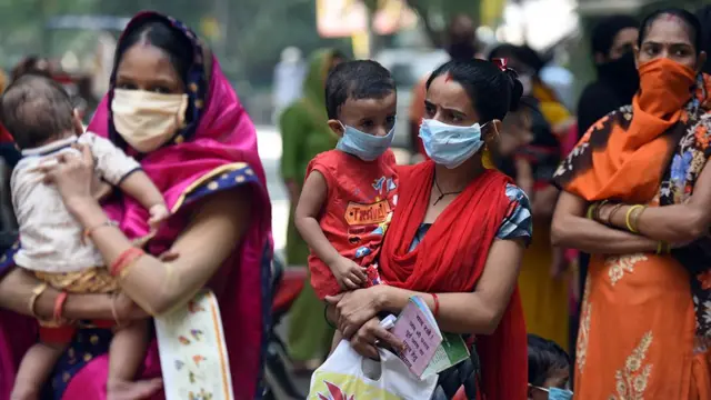 Women hold their children in Delhi