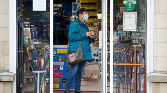 A woman in a shop wearing a face covering