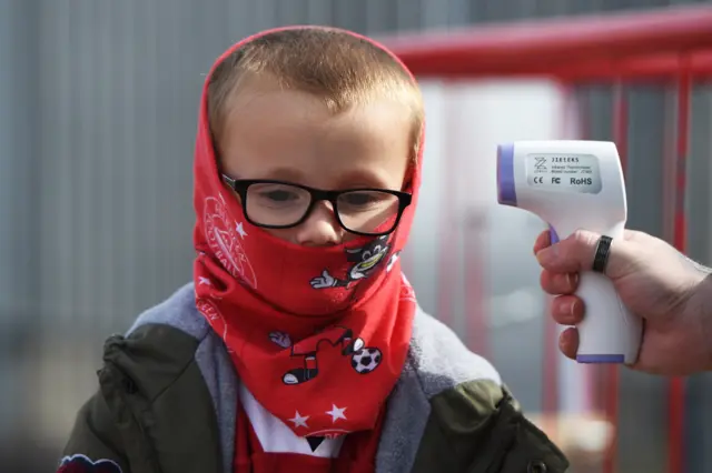 A young Aberdeen fan gets his temperature recorded before the game