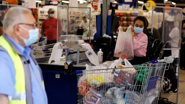 A woman loads a trolley at a supermarket in the Israeli city of Ashdod on 16 September 2020