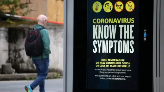 A man walking past a coronavirus sign