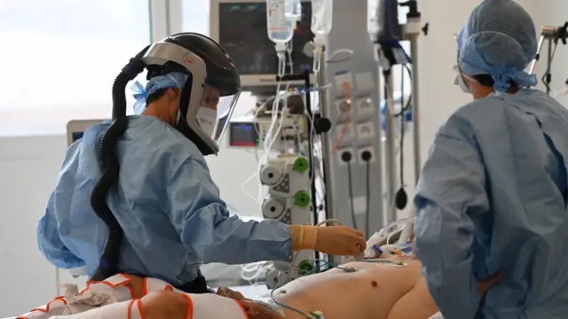 A medic checks the pulse of a patient at the emergency unit of La Timone hospital in Marseille, southeastern France, on 11 September, 2020.