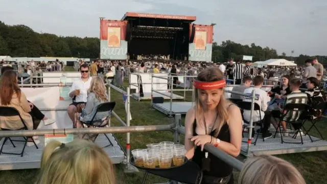 Waitress serves drinks at socially distanced gig